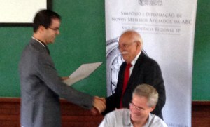 Prof. Nemmen receiving the award from Prof. Adolpho José Melfi